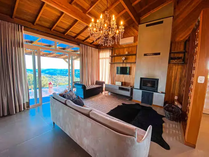 Sala do Chalé do Josef com lareira a lenha acesa